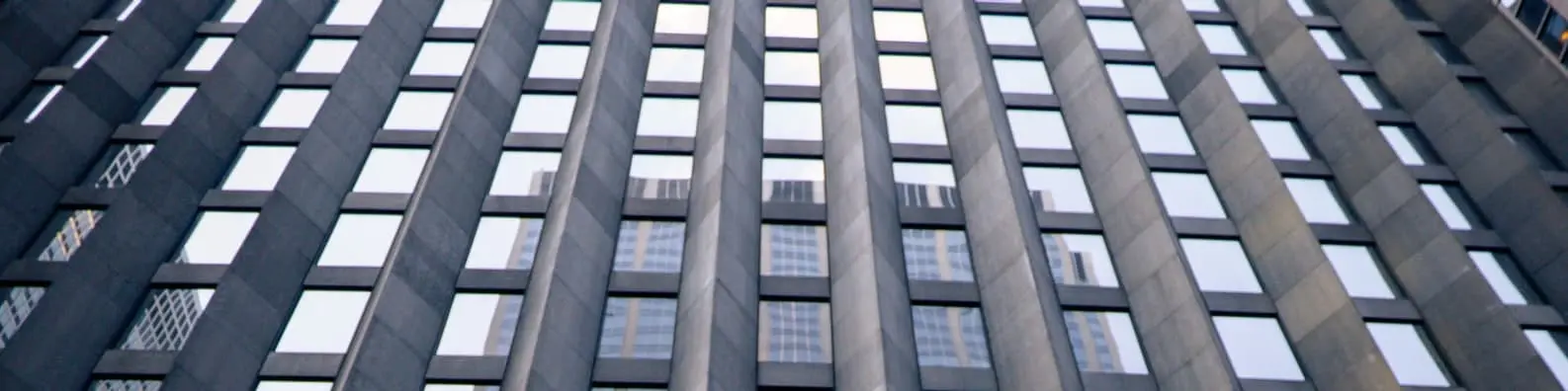 Sleek Glass Building With Mirror-Like Windows Background