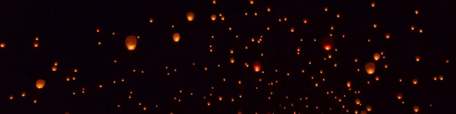glowing paper lanterns in night sky