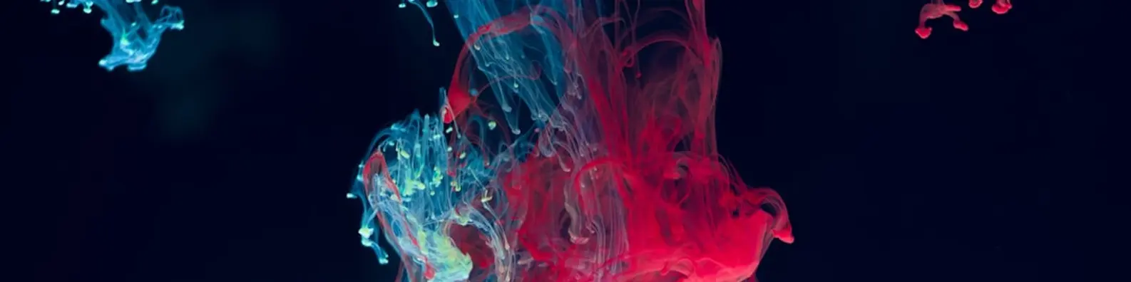 red and blue ink swirl in dark water